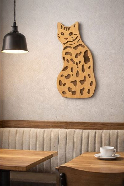 Wooden cat-shaped wall decoration on a wall in a cozy cafe setting.