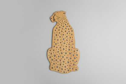 Wooden cutout of a cheetah shape on a dark background
