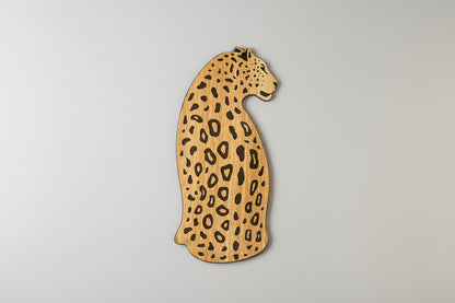 Wooden leopard-shaped cutting board on a light background