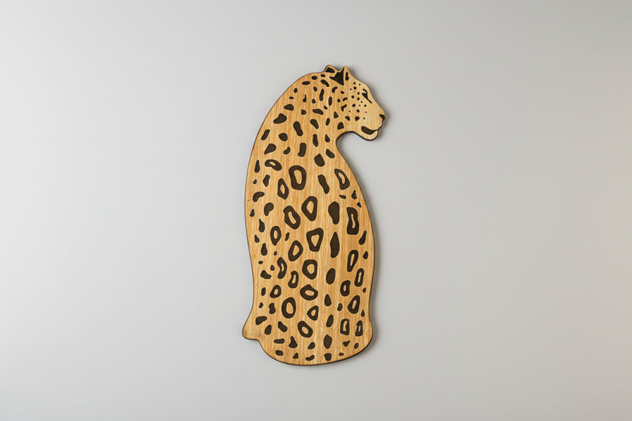 Wooden leopard-shaped cutting board on a light background