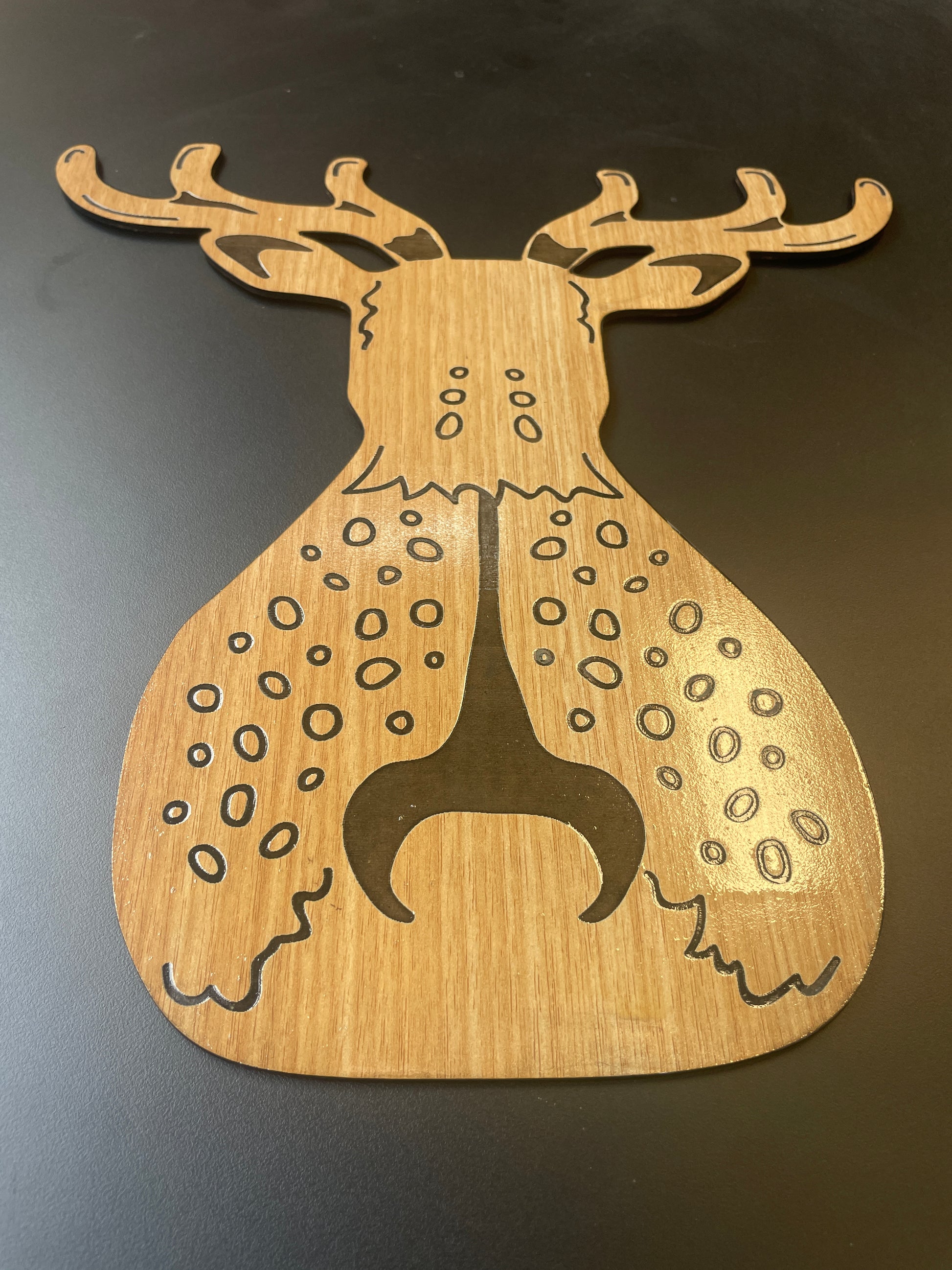 Wooden cuttlefish-shaped cutting board on a dark background