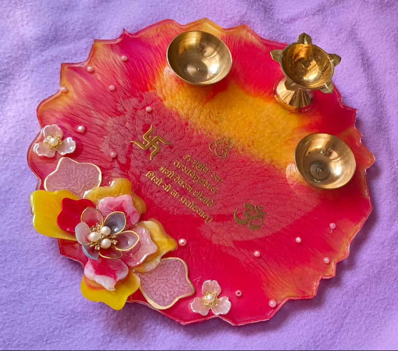 Decorative plate with flowers and gold elements on a purple fabric background