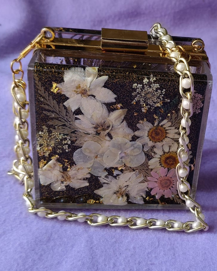 Floral handbag with a chain strap on a purple background
